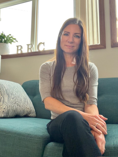 Lisa seated and welcoming visitors in the Blooming Roads Counseling office