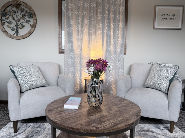 Two welcoming counseling chairs with flowers between them